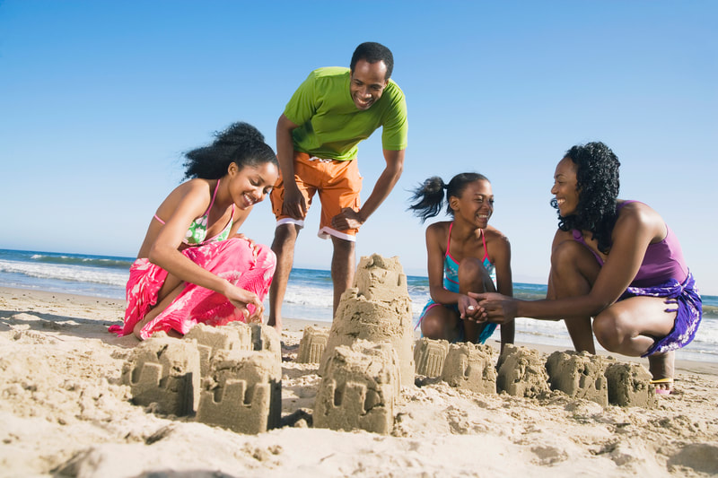 Family building sand castles on the beach. 