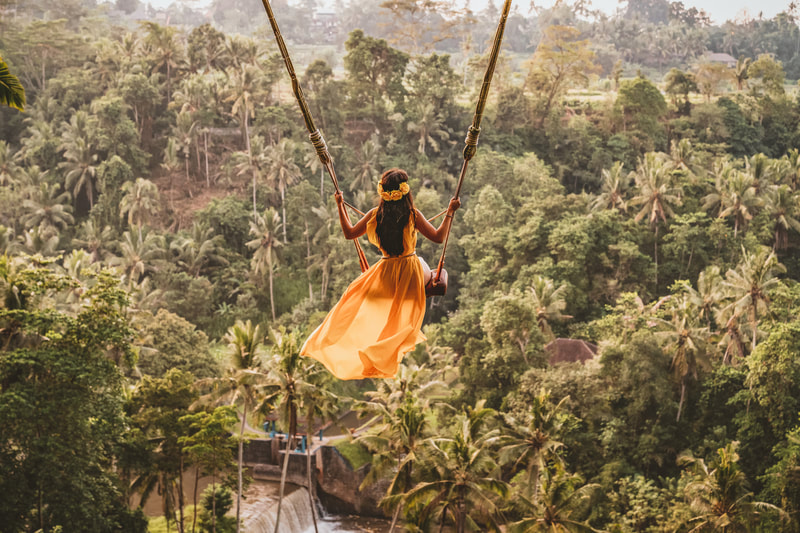A woman swinging on the jungle. 