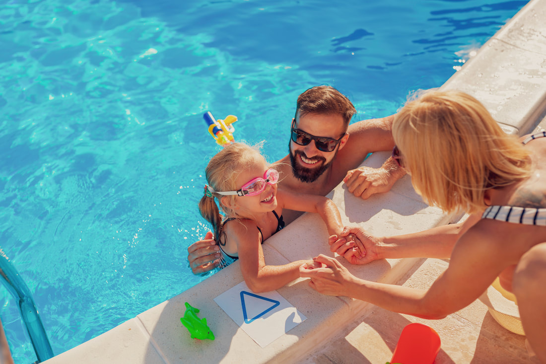 Couple in a pool with their child.