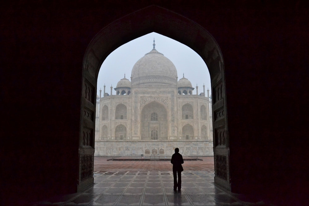 A solo traveler looking at the Taj Mahal. 
